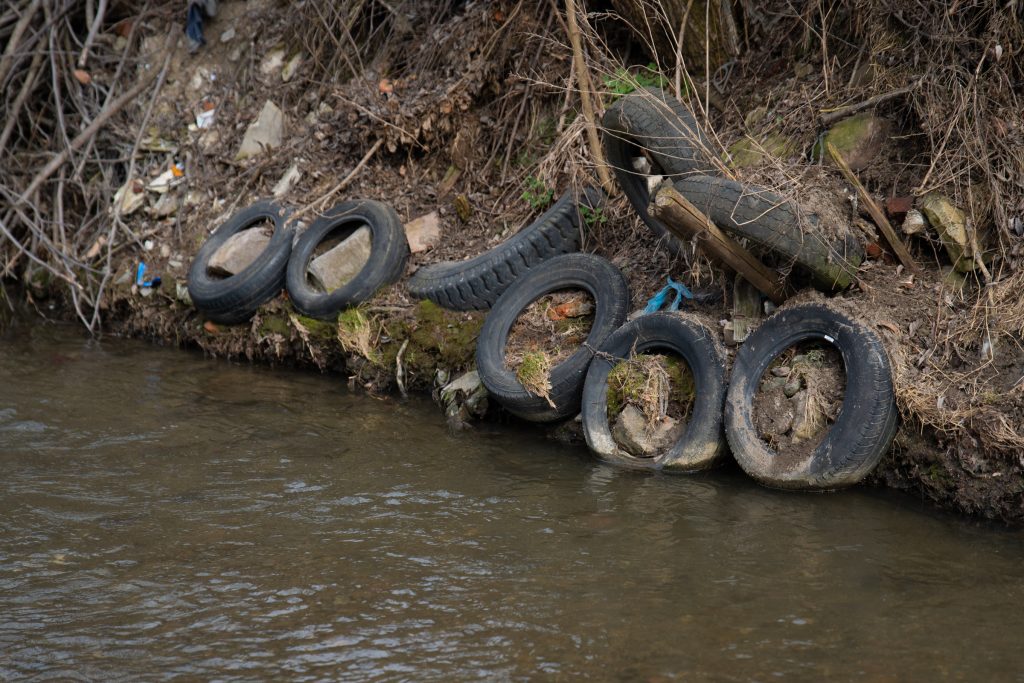 Bár elvileg kitakarították a környezetőrség figyelmeztetésére, az abroncsok továbbra is a patak szélén sorakoznak. Fotó: Tuchiluș Alex